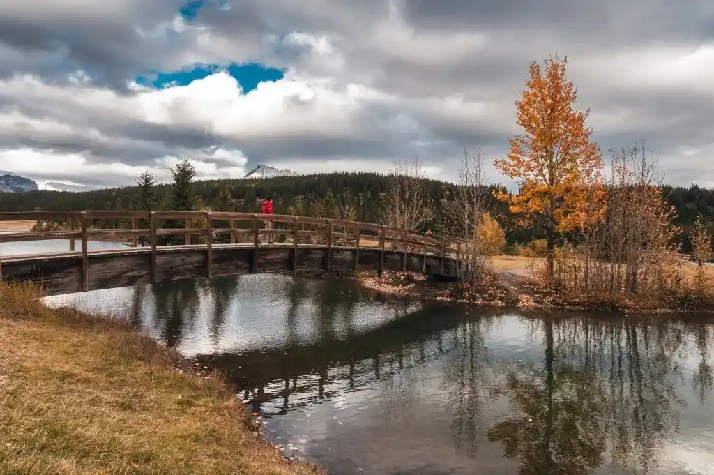 hombre-viajero-cruzando-puente-de-madera-en-el-lago-de-Banff